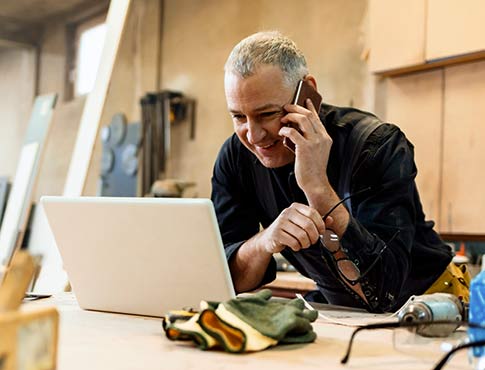 Businessman on the phone while looking at his laptop.