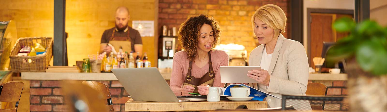 Small business owner meeting with a vendor at a table.