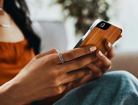 Person holding a phone while browsing online.