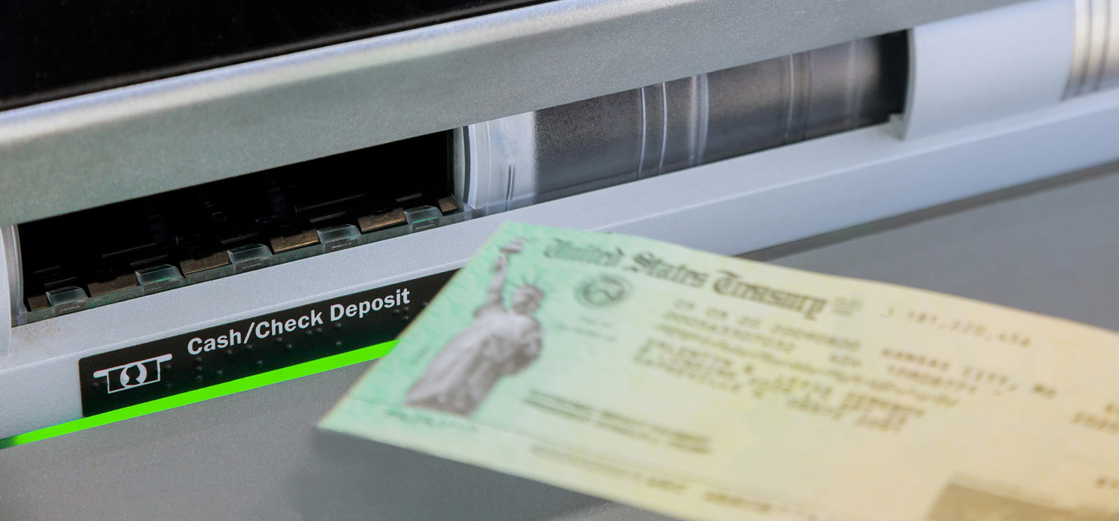 Person depositing a check into an ATM.